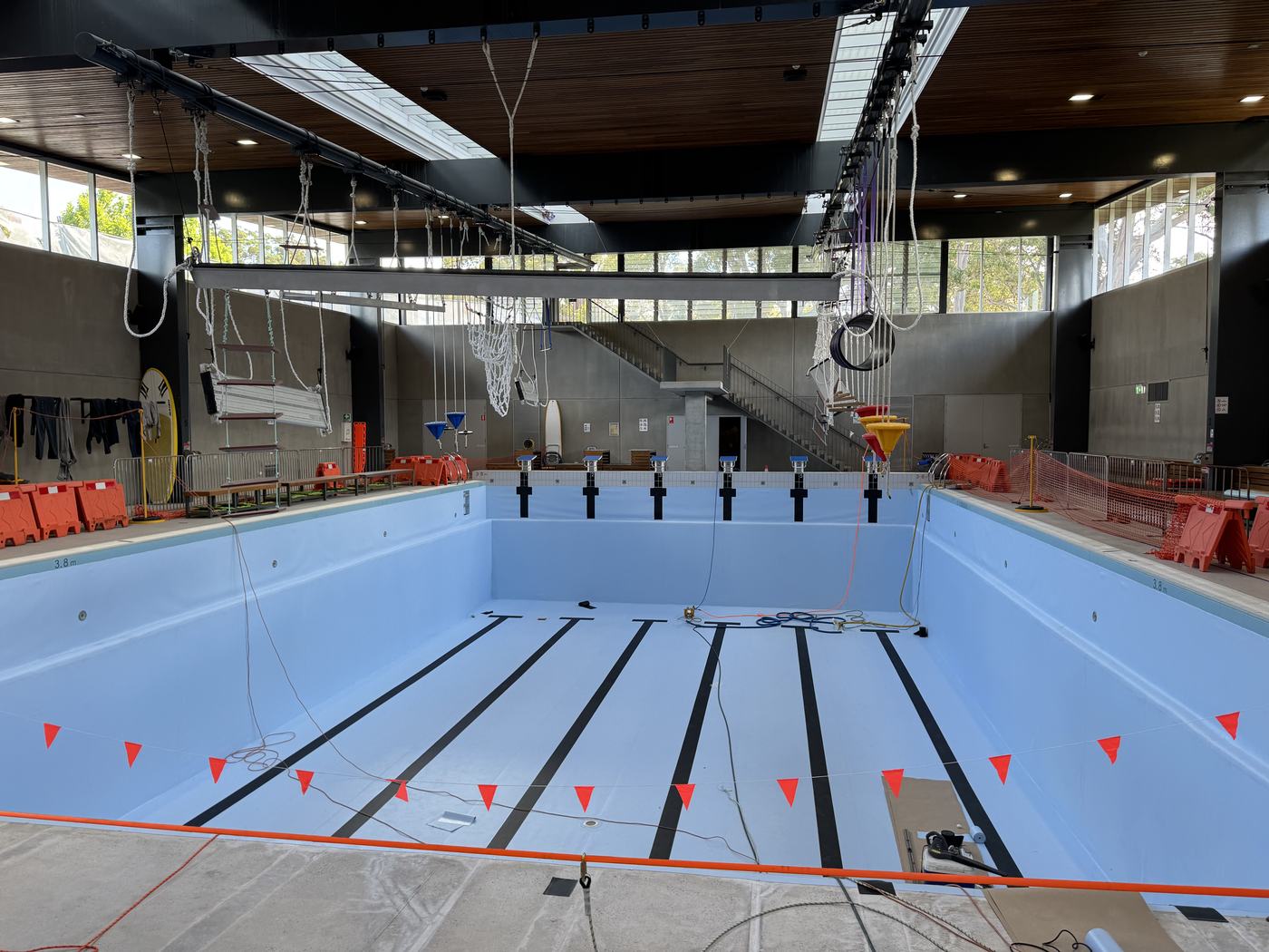 The same indoor pool with the floor and black lane markings lined