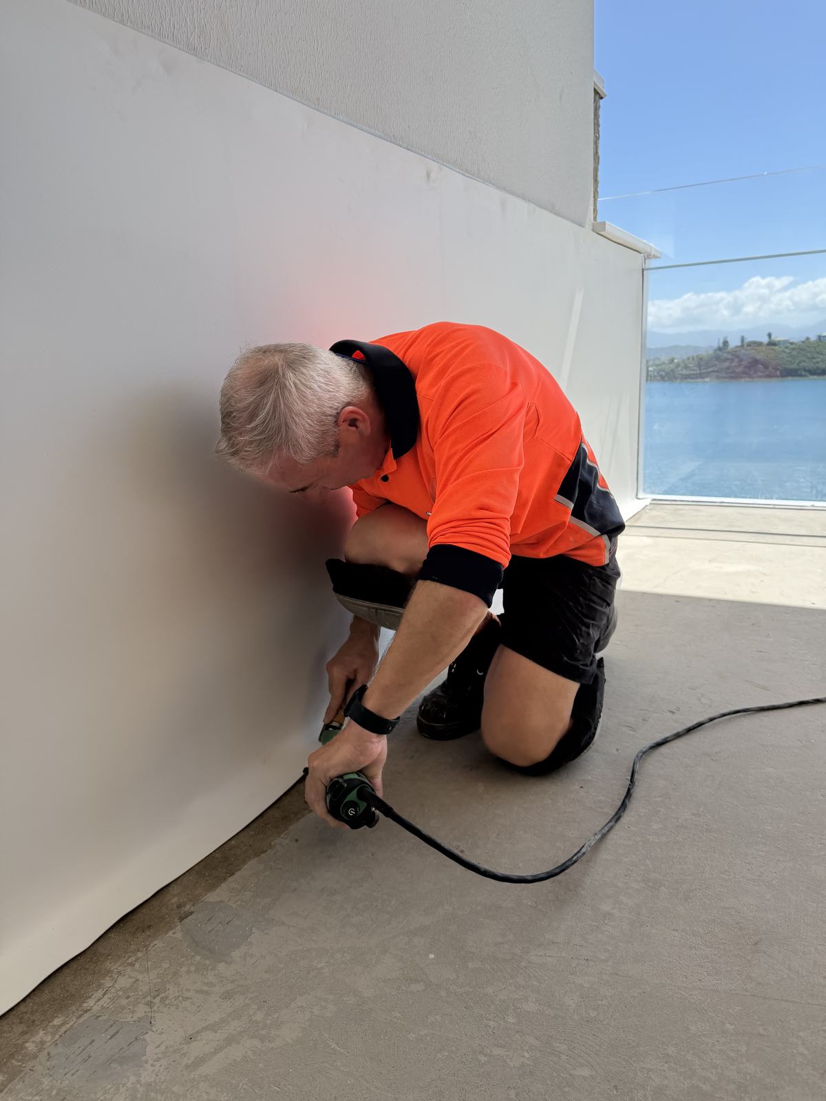 Installer heat-welding a pool membrane at the base of a wall